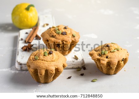 Autumn pumpkin muffins with spices, chocolate drops and pumpkin seeds.