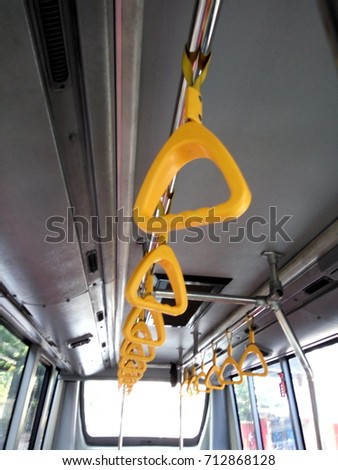 A row of yellow handle on a bus
