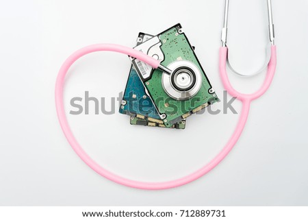 stethoscope and hard disk drive on white background. Computer hardware diagnostic and repair concept
