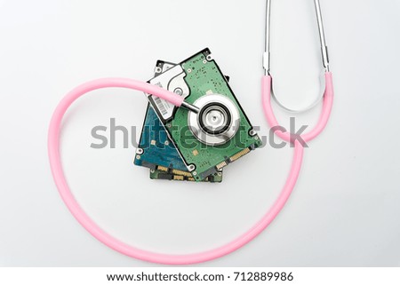 stethoscope and hard disk drive on white background. Computer hardware diagnostic and repair concept