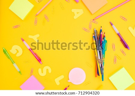 back to school or office styed frame with multicolored school supplies on yellow background with copy space