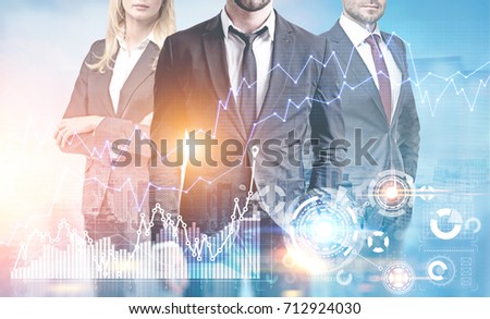 Unrecognizable business team members are standing against a cityscape. There are graphs and HUD in the foreground. Toned image double exposure