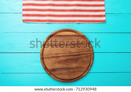 Frame of round cutting board and red striped tablecloth. Blue wooden background in the cafe. Top view and mock up. Thanksgiving day