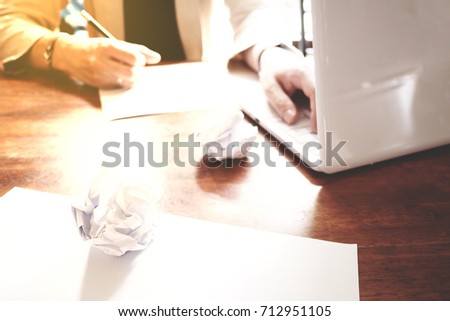 The picture of Asian Businessmen are saddened by the failure of his work on wooden table at office, consist of white laptop, paper, and hands. selective focus