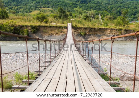 Suspension cable bridge, Crossing the river, ferriage in the woods. Adygea republic, Krasnodar region, Russia. Royalty-Free Stock Photo #712969720