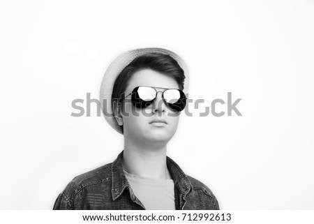 Handsome man with sunglasses and hat on a white background in studio