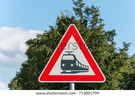 A triangular street sign for train tracks close up