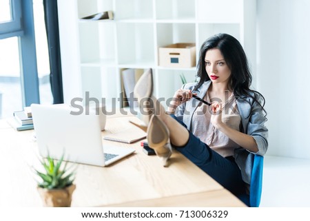young businesswoman sitting at workplace with laptop in office