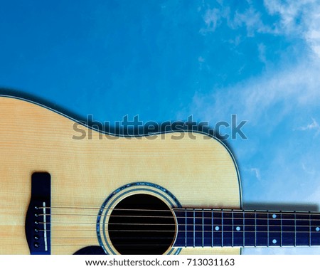 The wooden guitar on the background.