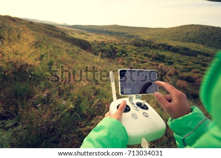 hands with remote controller of drone in the forest 