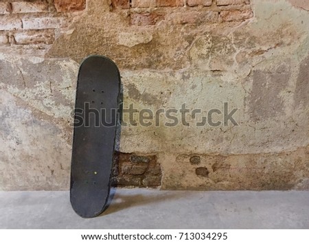 Old Skateboard on Cement with Old Brick Wall in Vintage Style  Royalty-Free Stock Photo #713034295