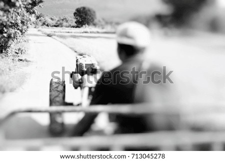 Men are driving a vehicle adapted from farm tractor in Thailand. This image was blurred or selective focus. Black and white picture.
