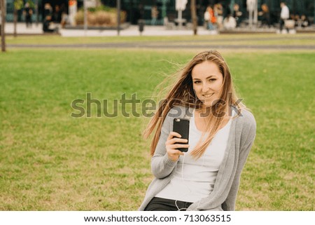 young girl hearing a music with smart phone outdoor