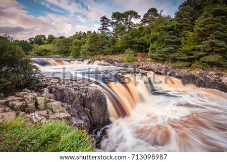 River Tees cascades over Low Force / The River Tees cascades over the Whin Sill at Low Force Waterfall, as the Pennine Way follows the southern riverbank Royalty-Free Stock Photo #713098987