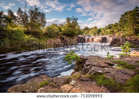 River Tees and Low Force Waterfall / The River Tees cascades over the Whin Sill at Low Force Waterfall, as the Pennine Way follows the southern riverbank Royalty-Free Stock Photo #713098993