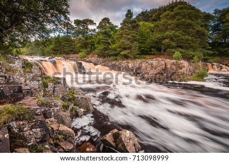 Low Force and Whin Sill / The River Tees cascades over the Whin Sill at Low Force Waterfall, as the Pennine Way follows the southern riverbank Royalty-Free Stock Photo #713098999
