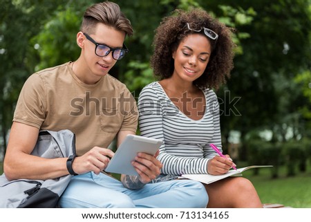 Cheerful guy and girl learning subject together