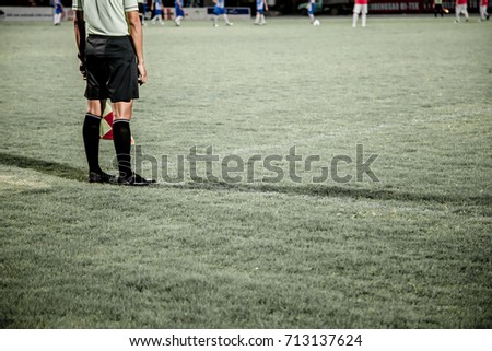 Motion blur Assistant referee or linesman are moving along the sideline during a soccer match or football match at the stadium .