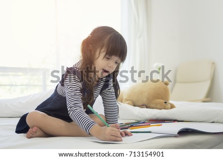 Happy children drawing on a large sheet of paper