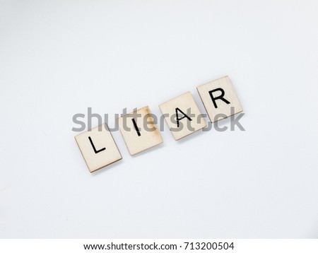 The word "Liar" spelled out with wooden letter tiles.