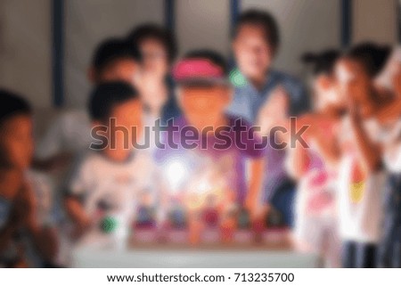 Blurred abstract image of birthday party with many children celebration by blowing the cake candle