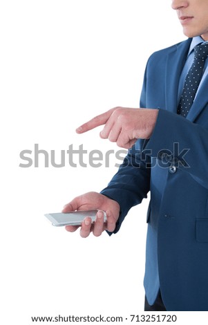 Mid section of businessman gesturing over mobile phone while standing against white background