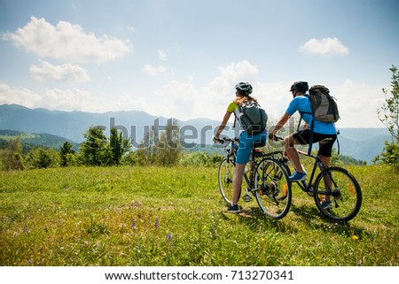ACTIVE Young couple biking on a forest road in mountain on a spring day Royalty-Free Stock Photo #713270341