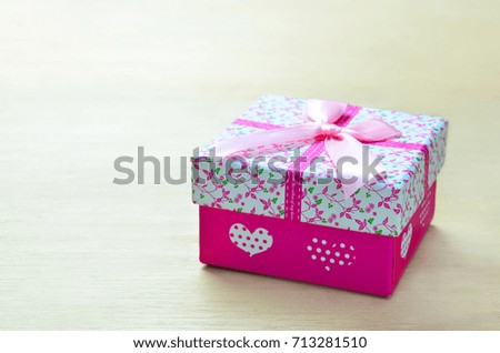Pink gift box on wood background with copy space.