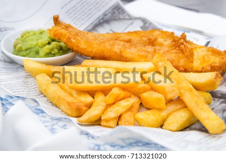 Traditional English Food such as Fish and Chips with mushy peas served in the Pub or Restaurant Royalty-Free Stock Photo #713321020