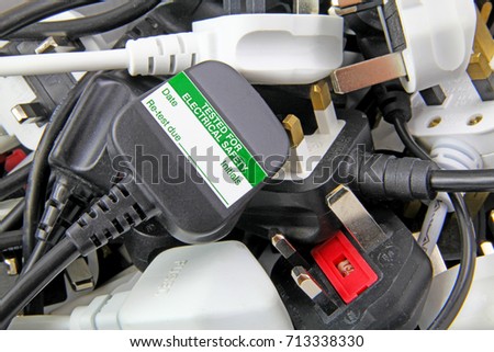plan view of plugs – Blurred background of  three pin plugs with top of plug  with test sticker Royalty-Free Stock Photo #713338330