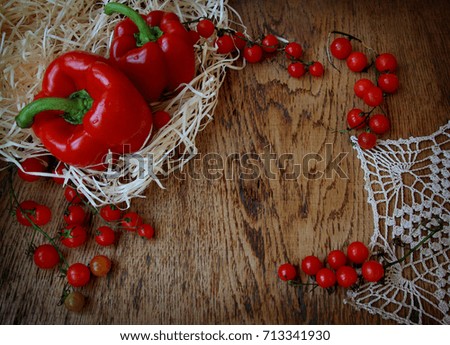 Still life of pepper and cherry tomatoes on a wooden table with decor