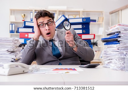 Male businessman with magnifying glass in office