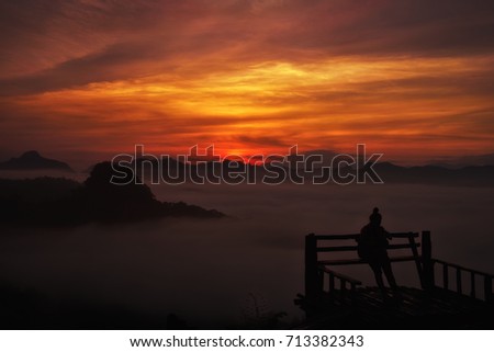 People with big sphere of sun and sunlight on silhouette  with mist and golden light at sunset. Amazing sun landscape with fluffy cloud. Colorful dramatic twilight sky with valley of mountain
