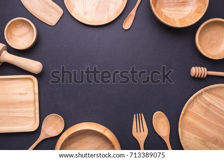 Collection of new wooden kitchen utensil, bowl, plate, spoon, dish. Studio shot on black table background. With free space for text or design