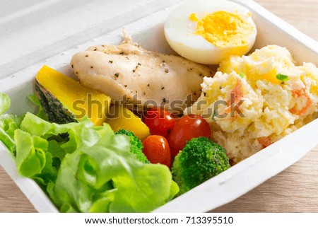 Healthy salad with tomatoes, chicken, egg, mash potato, and mixed greens (Broccoli, pumpkin) on wooden background. Healthy food.