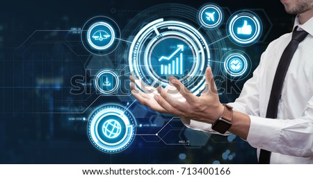 Young businessman working in his futuristic office using virtual screen. Modern business and technologies concept.