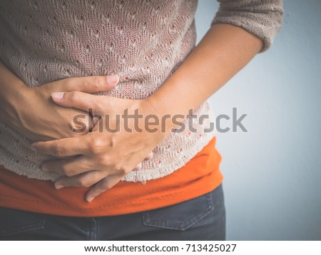 Young woman having painful  stomachache. Chronic gastritis. Abdomen bloating concept. Royalty-Free Stock Photo #713425027