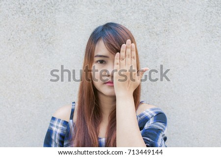 Smiling young beautiful asian woman closing her eyes with hands on concrete wall background. Vintage effect style pictures.