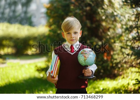 Cute boy going back to school. Child with books and globe on first school day