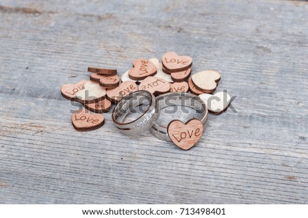 silver wedding rings with wooden hearts love on wooden plank