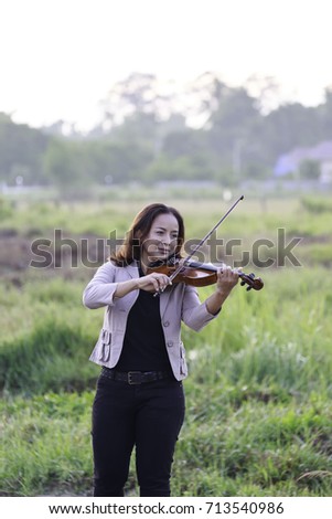 a woman plays violin in the morning