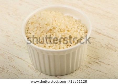 Raw rice heap in the bowl - ready for cooking