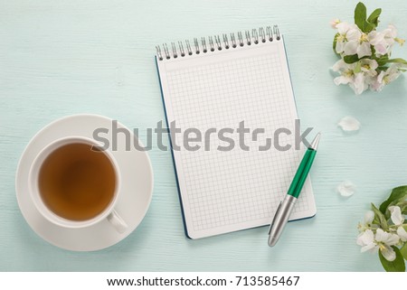   Notepad, pen, flowers and cup of tea
