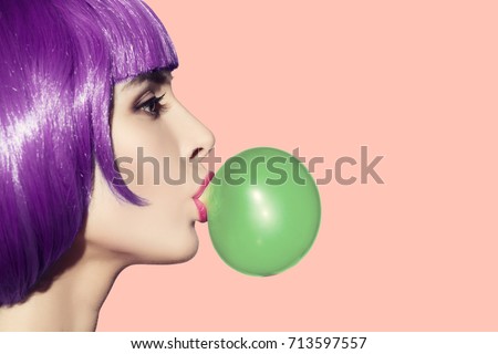 Pop art woman blowing bubble gum. Side view on pink background. Royalty-Free Stock Photo #713597557