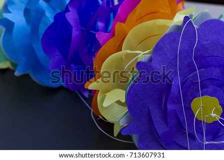 A paper garland over a black background
