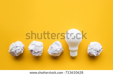 Creativity inspiration,ideas concepts with lightbulb and paper crumpled ball on pastel color background.Flat lay design.