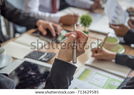 Key to success, Woman's hand  holding a pen to taking notes at a business meeting for personal reference, while meeting minutes are for official record-keeping purposes. Royalty-Free Stock Photo #713629585
