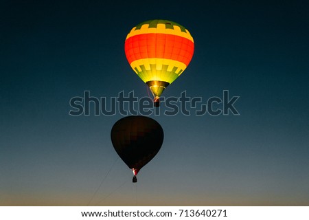 Glowing and blinking balloons flight with people high in sky in night. Freedom concept. Romantic recreation. Hot air balls competition. Autumn ballooning festival. Travel and tourism. Airship journey.