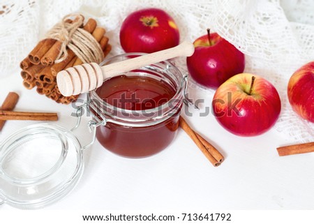 honey spoon, jar of honey, apples and cinnamon on a wooden background in a rustic style (toning)