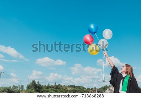 A Girl handing balloon with colorful on blue sky,vintage tone.